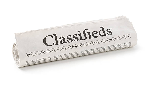 Rolled newspaper with the headline Classifieds Rolled newspaper with the headline Classifieds classified ad stock pictures, royalty-free photos & images