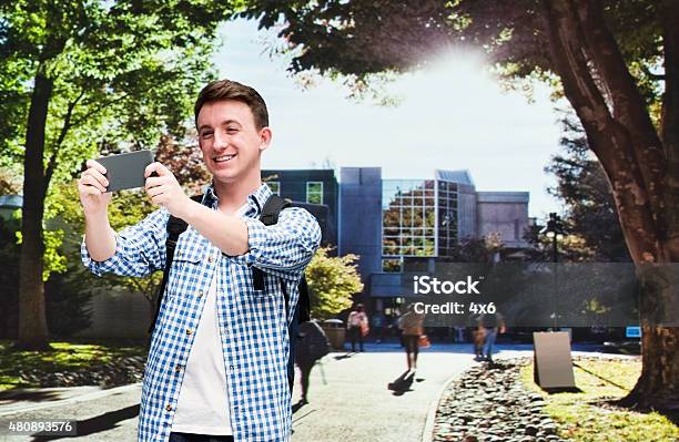 Smiling Male Student Taking A Selfie In University Stock Photo - Download Image Now - 20-29 Years, 2015, 25-29 Years