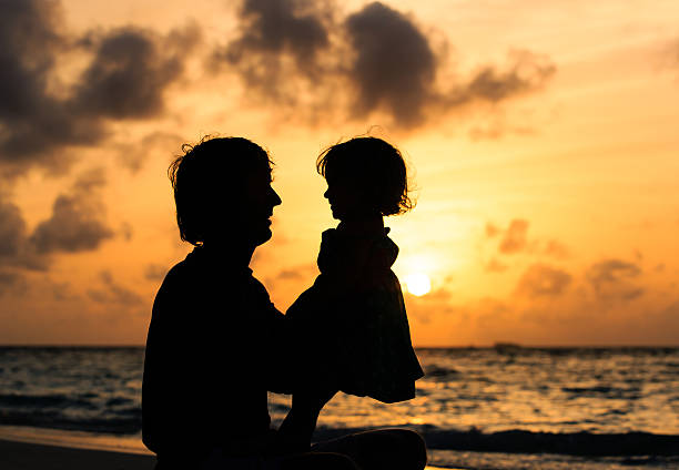 istock Father and little daughter silhouettes at sunset 480893890