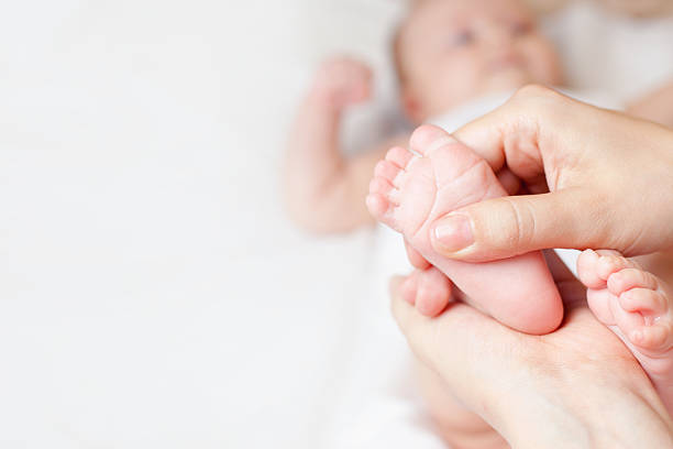 madre de bebé feliz hace de masajes - newborn baby human foot photography fotografías e imágenes de stock