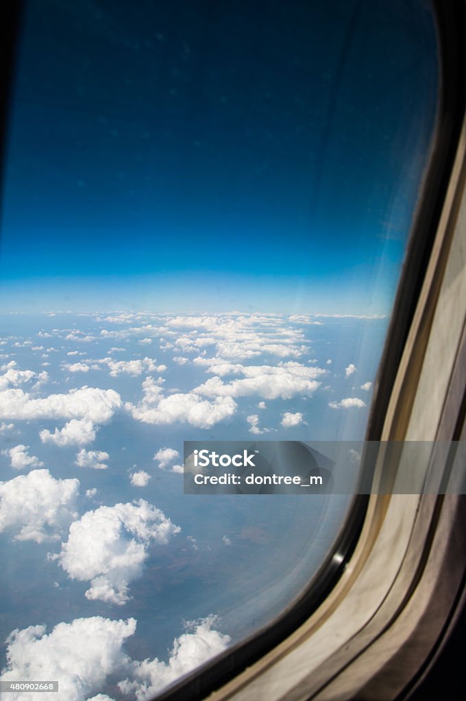 airplane window with wing and cloudy sky behind 2015 Stock Photo