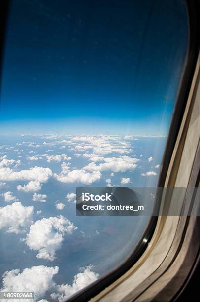 Airplane Window With Wing And Cloudy Sky Behind Stock Photo - Download Image Now - 2015, Air Vehicle, Airplane