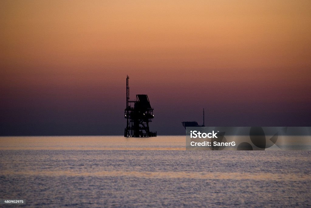 Huile plate-formes et le coucher du soleil - Photo de Bleu libre de droits