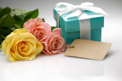 roses & gift with label on white ground