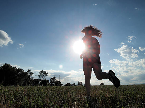 istock woman running across field 480908858