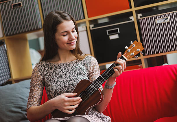 istock young beauty woman playing on ukelele 480911470