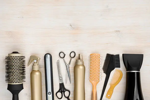 Photo of Hairdressing tools on wooden background with copy space at top