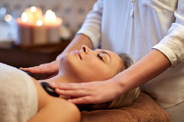 gros plan de femme ayant le massage aux pierres chaudes au spa - spa treatment health spa wellbeing lastone therapy photos et images de collection