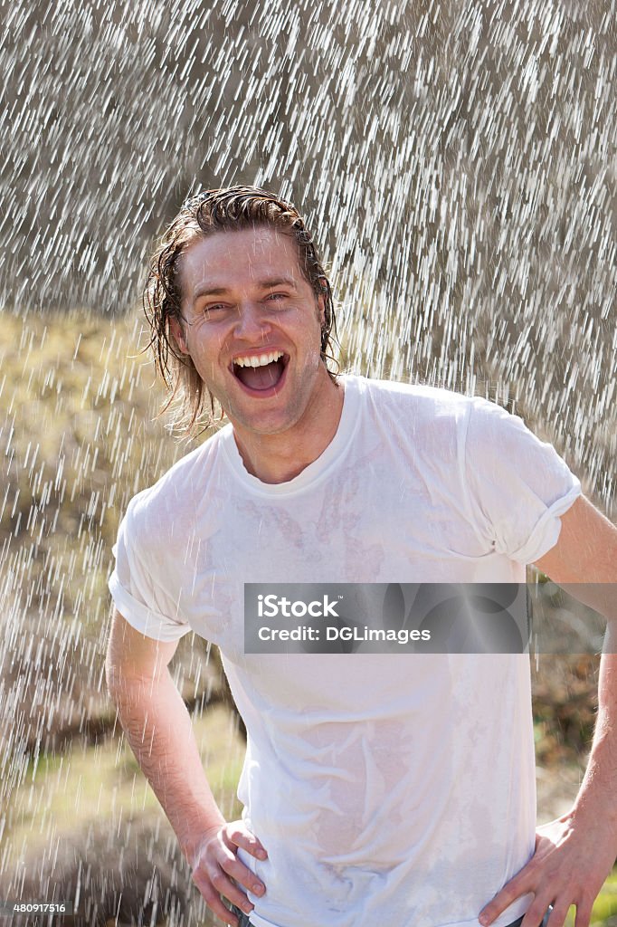 Male having fun in the rain An attractive young man having fun in the rain without an umbrella Wet Stock Photo