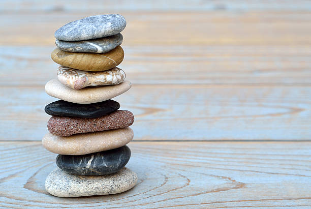 istock Grey cairn zen stones on blue old wooden empty background 480920528
