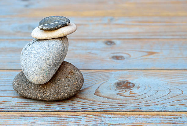 istock Grey cairn zen stones on blue old wooden empty background 480920564