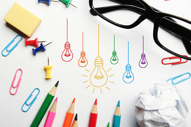 Light bulbs Light bulbs with some office supplies around it on white background. roots music stock pictures, royalty-free photos & images