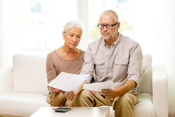 istock senior couple with papers and calculator at home 480922086