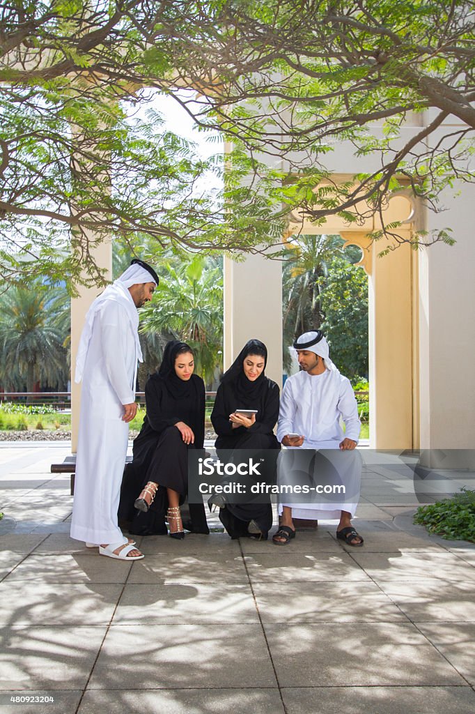 Emirati business group Four Emirati business men and women looking at digital tablet, communicating before business meeting in a business district in Dubai, UAE. Student Stock Photo