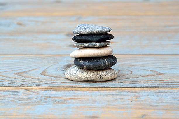 istock Grey cairn zen stones on blue old wooden empty background 480923512