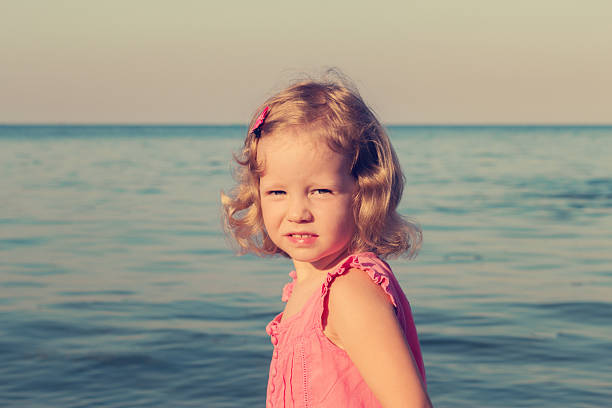 Happy, funny little girl on sea, selective focus.