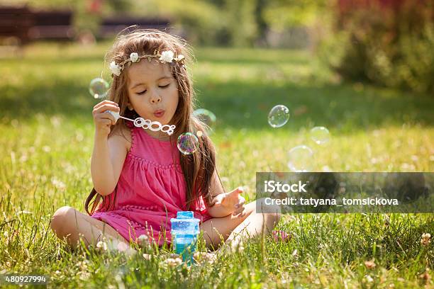 Beautiful Portrait Of Sweet Lovely Little Girl Blowing Soap Bubb Stock Photo - Download Image Now