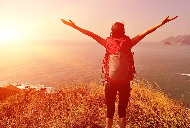 istock hiking woman cheering seaside 480931719