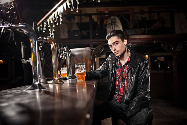 istock was a hard day. Depressed  man drinking beer in bar 480935530
