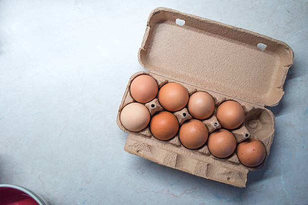 Nine Eggs in an Egg Box/Carton Eggs on a kitchen counter, with one egg missing from the 10 egg egg carton. egg carton stock pictures, royalty-free photos & images