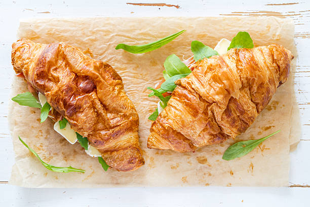 istock Croissant sandwich with ham, cheese, white wood background 480940722