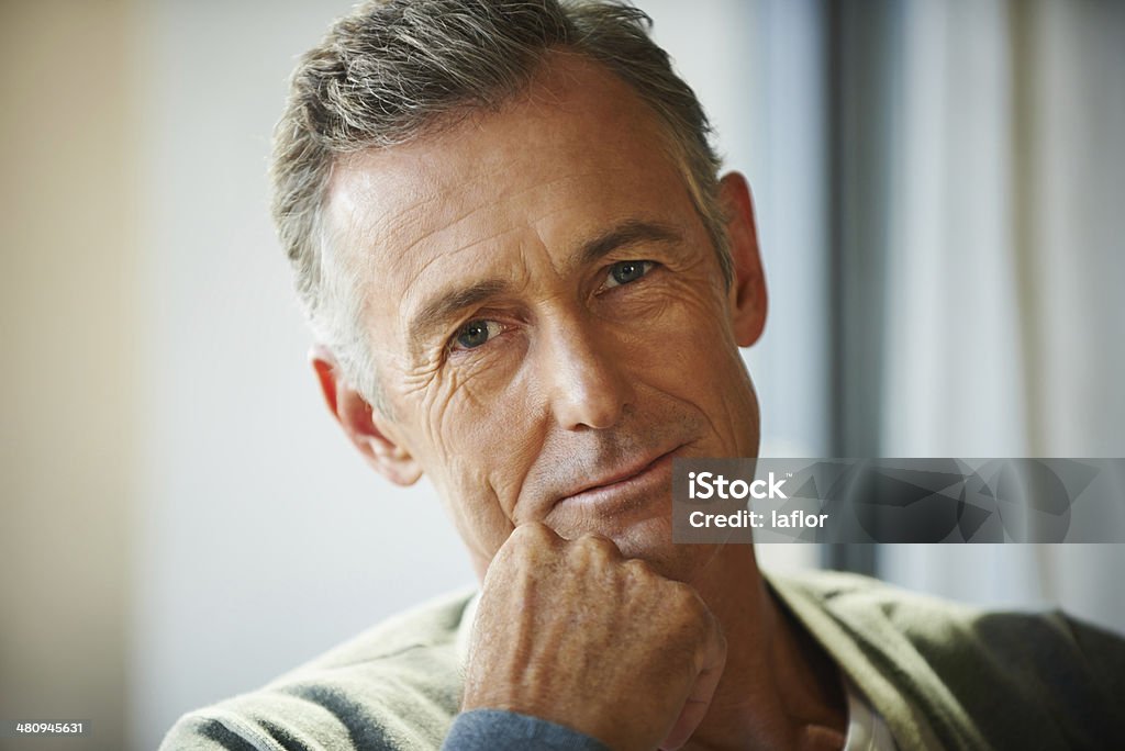 Reflecting on his life Closeup shot of a handsome mature man with his hand on his chin Close-up Stock Photo