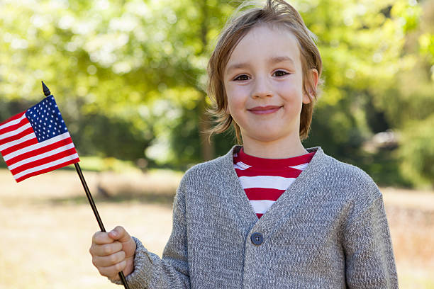 istock Cute little boy waving american flag 480947764