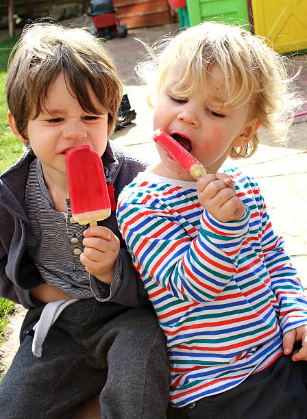istock Brothers eating ice lollies 480949801