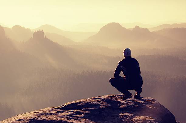 istock Young man in black sportswear is sitting on cliff's edge 480951614