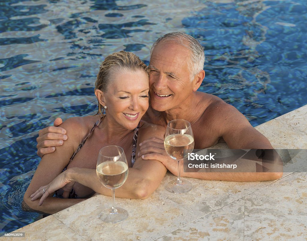 Senior Couple By The Swimming Pool Senior Couple In A Swimming Pool 60-64 Years Stock Photo