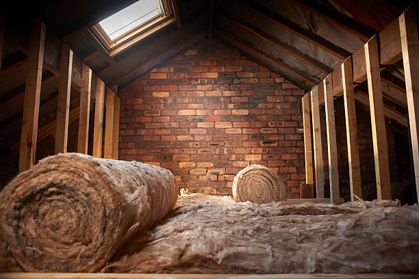 loft insulation rolls of insulation partially installed in a loft space. insulation stock pictures, royalty-free photos & images