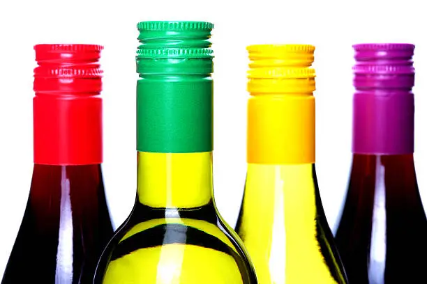 Four Bottles of WIne, Two White Wine, Two Red Wine, showing the tops of the bottles with different coloured lids and screw tops, a concept picture, alcohol, beverage, drink, wine, isolated against a white background, clipping path or cut out