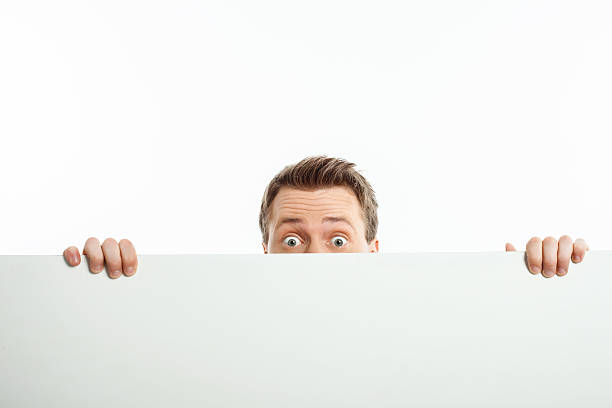 istock Attractive young man is hiding behind white wall 480957156
