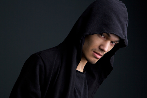 Portrait of a male fashion model with hooded sweat shirt on gray background