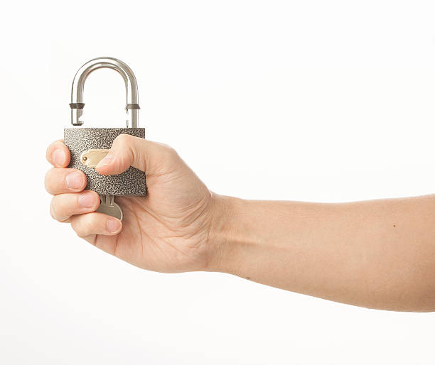 Hand holding padlock on white stock photo
