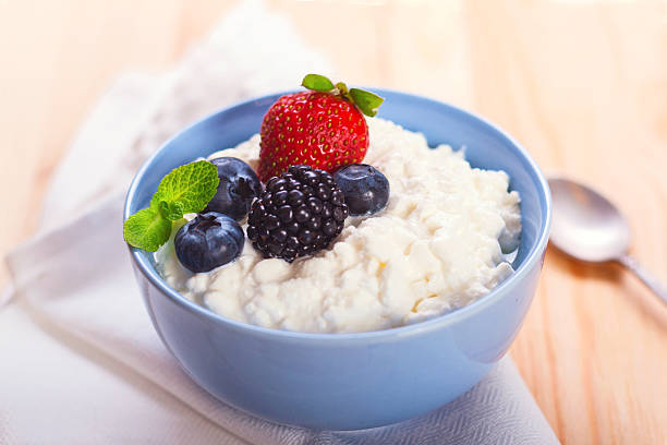 Cottage cheese with berries Close-up of homemade cottage cheese with strawberry, blueberries and blackberry, horizontal stock photo cottage cheese photos stock pictures, royalty-free photos & images