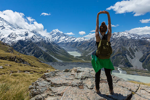 Woman Traveler with Backpack hiking in Mountains