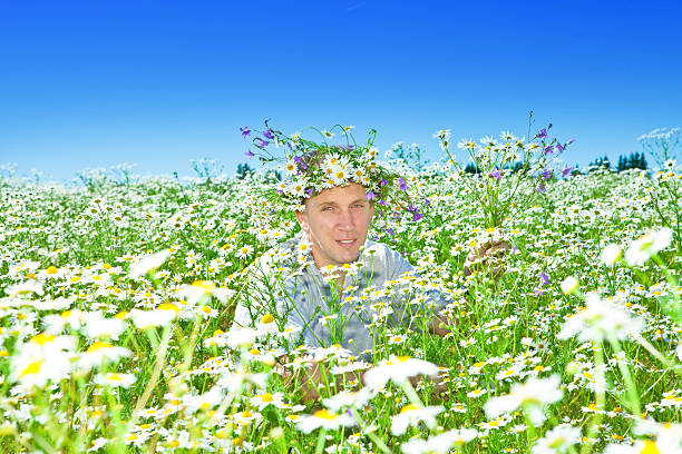 istock The smiling man in a wreath from wild flowers 480965554