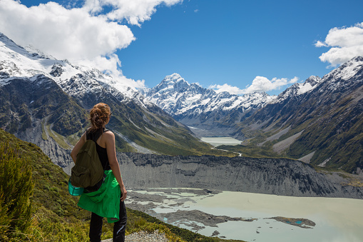 Woman Traveler with Backpack hiking in Mueller Hut Route, Mount Cook National Park, New Zealand