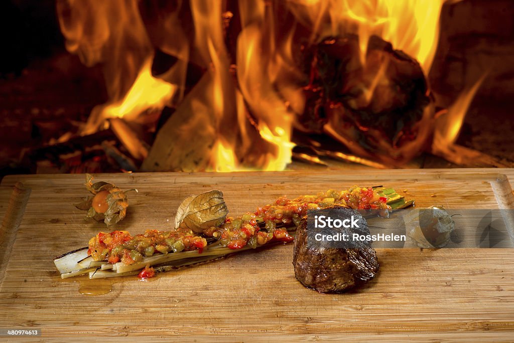 Delicious beef steaks, wooden desk and fire Delicious beef steaks on wooden desk and fire on background Animal Blood Stock Photo