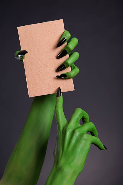 istock Green monster hands holding blank piece of cardboard 480974734