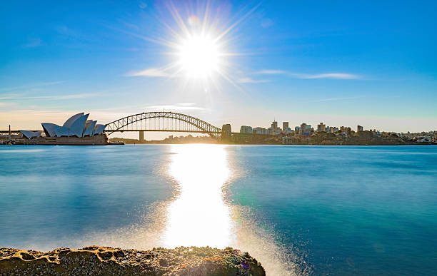 Sunshine over calm waters Photo of Sydney Harbour and Government owned public historic landmarks Sydney Opera House and Sydney Harbour Bridge. sydney harbor stock pictures, royalty-free photos & images