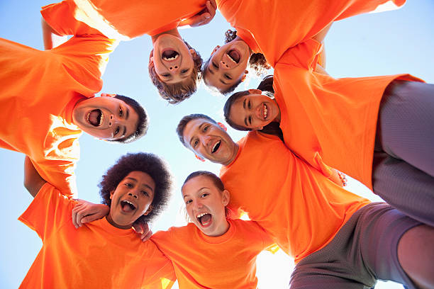 entrenador con grupo de niños - orange uniform fotografías e imágenes de stock