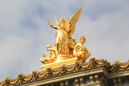 Golden statue on top of the Opera house in Paris.