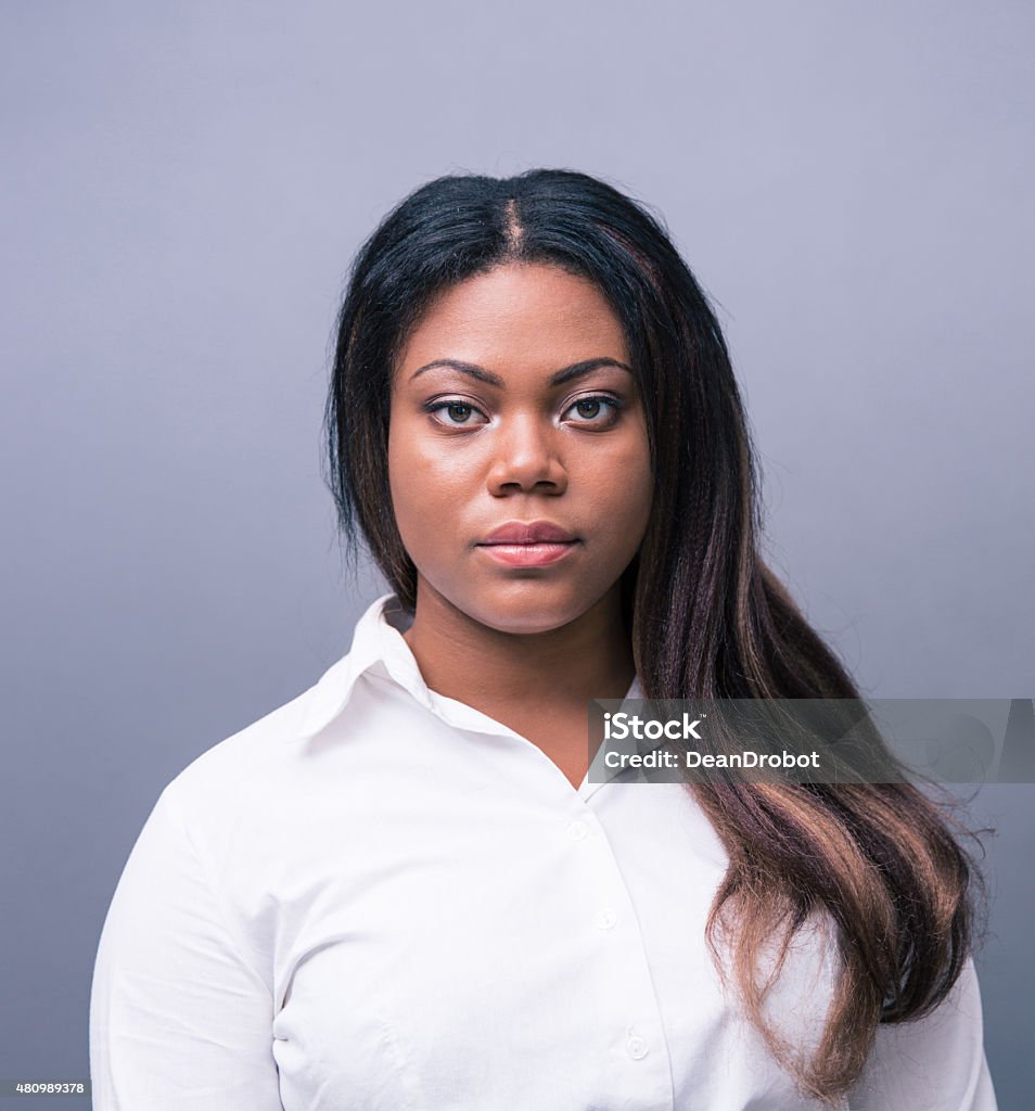 Portrait of a serious african businesswoman Portrait of a serious african businesswoman over gray background. Looking at camera 2015 Stock Photo