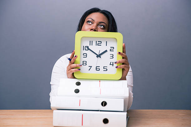 istock African businesswoman sitting at the table with clock 480990066