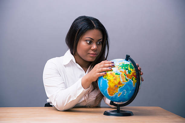 istock African businesswoman sitting at the table with globe 480990142