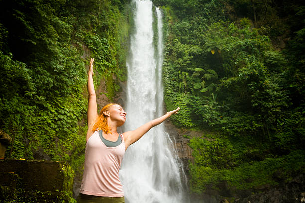 istock Young woman practicing yoga by the waterfall 480991593