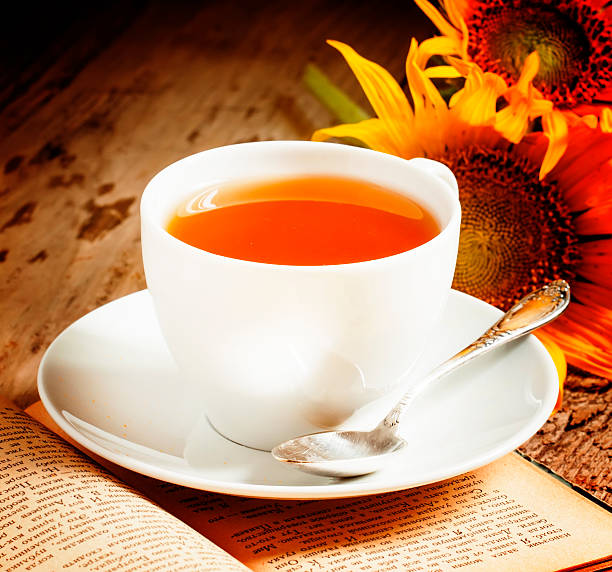 istock cup of black tea, sunflowers, old books 480995728