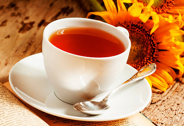 istock cup of black tea, sunflowers, old books 480995730